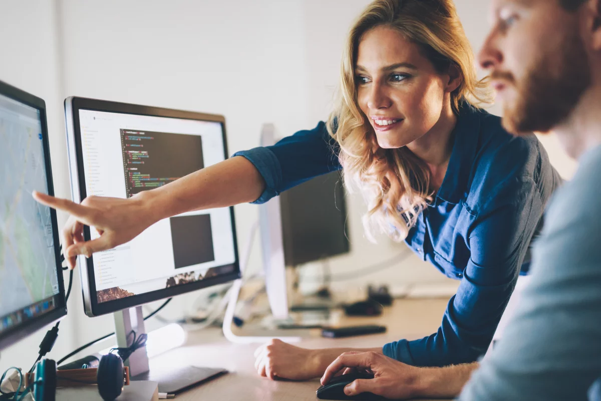 mlad8 6ena programátorka ukazuje kolegovi programátorovi na monitor